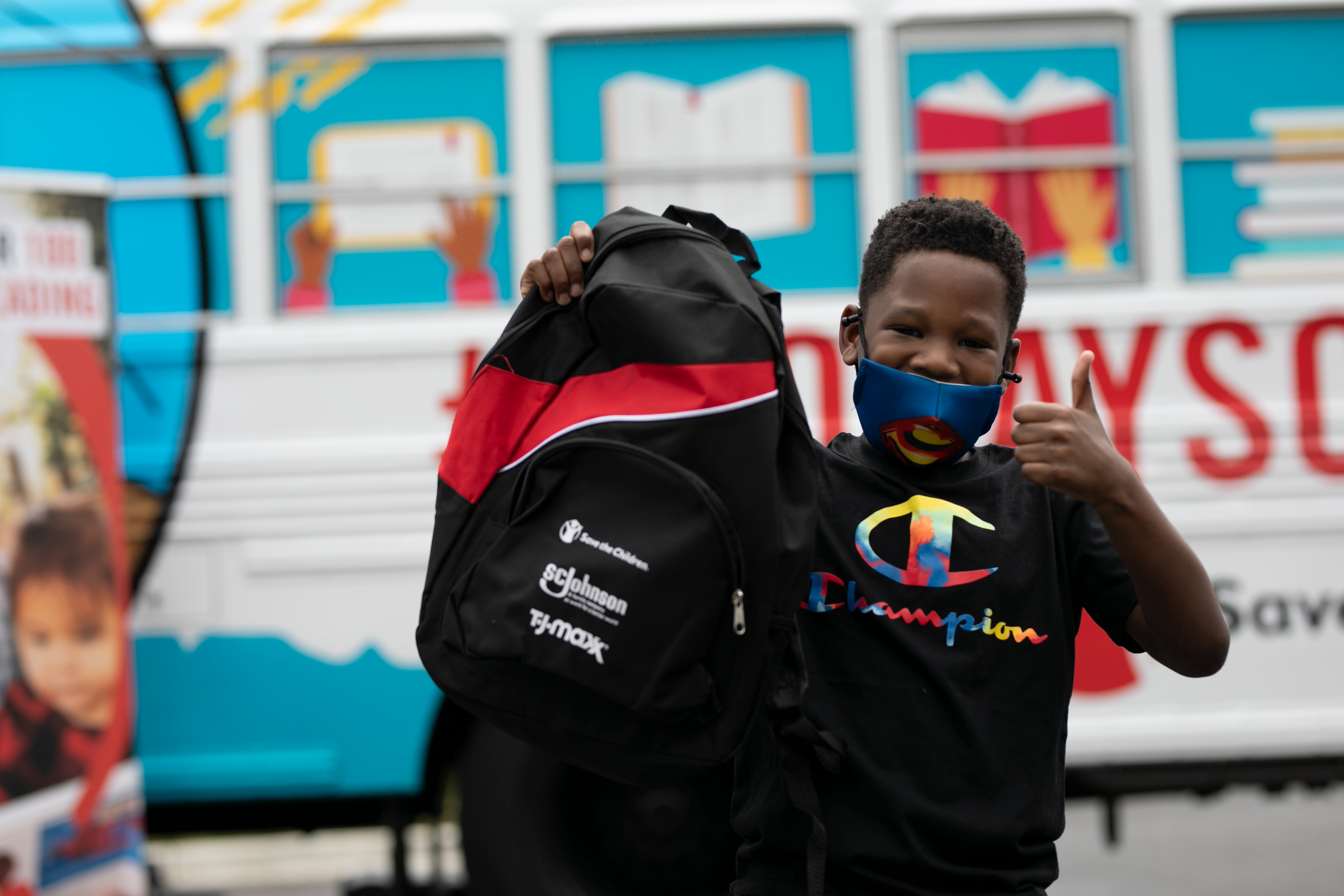Child Holding Up SC Johnson Sponsored Back pack