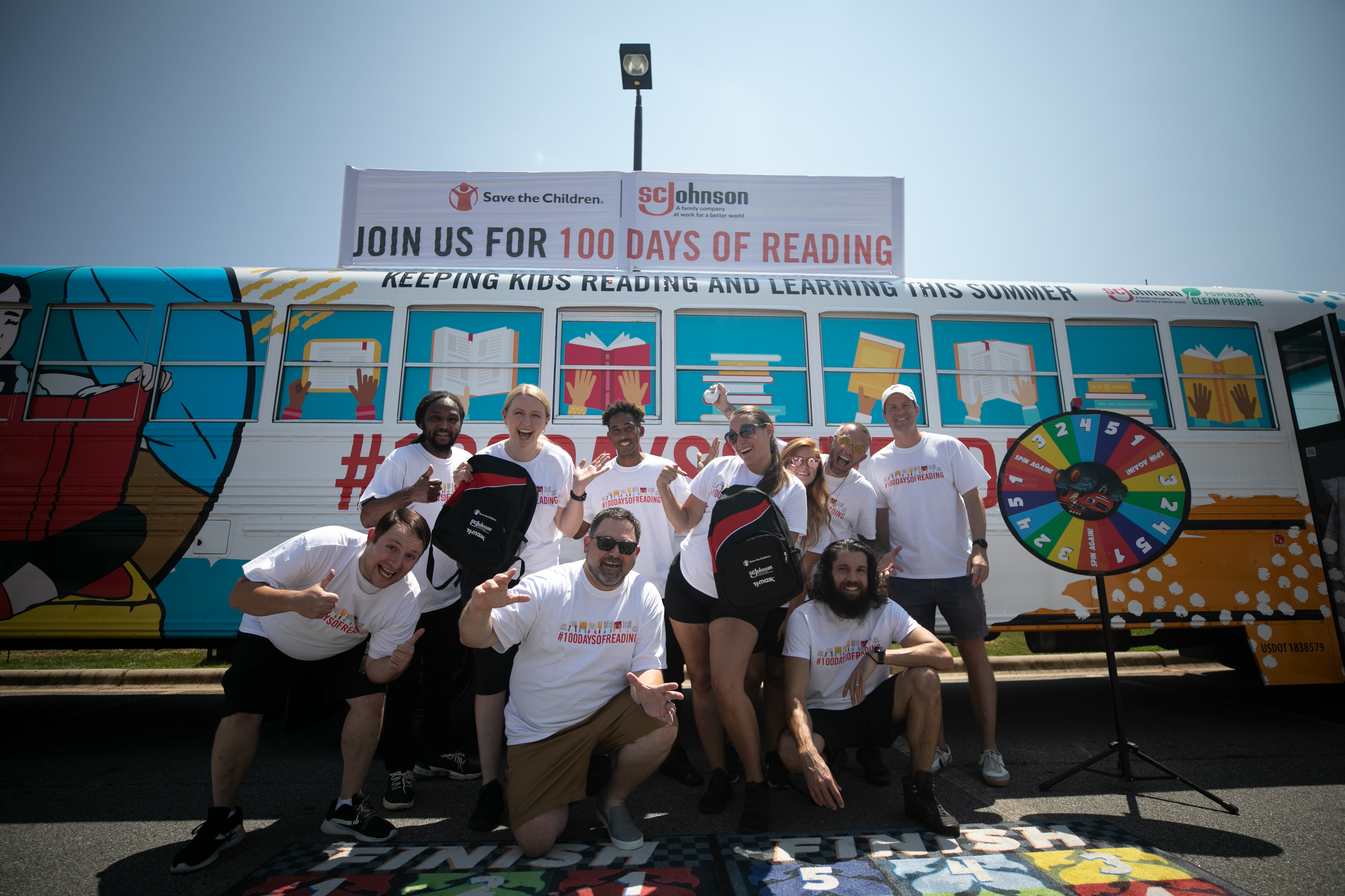 Group of adults in front of 100 days of reading bus