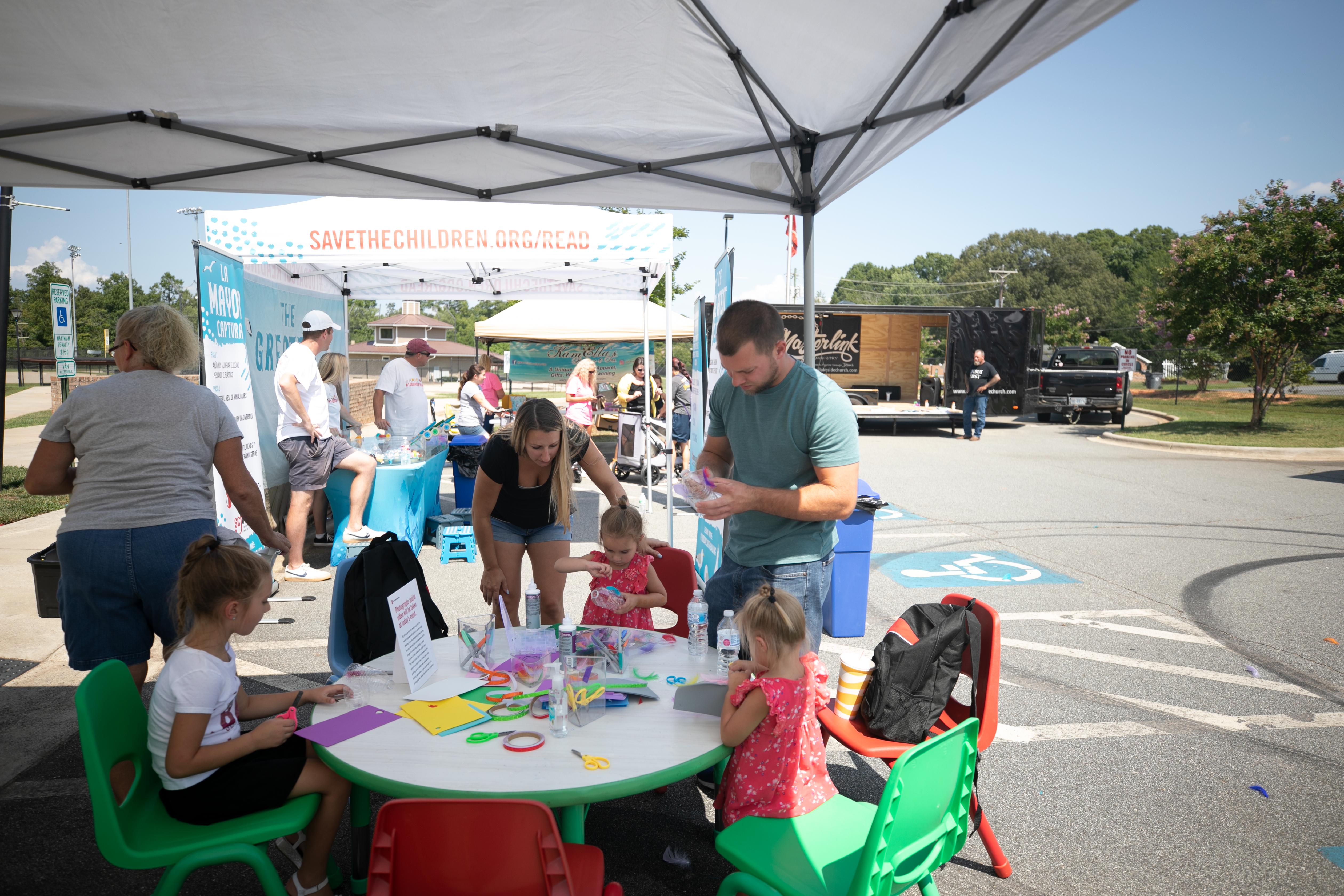 Children at white table outside coloring